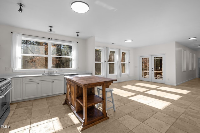 kitchen featuring white cabinetry, french doors, stainless steel range oven, and sink