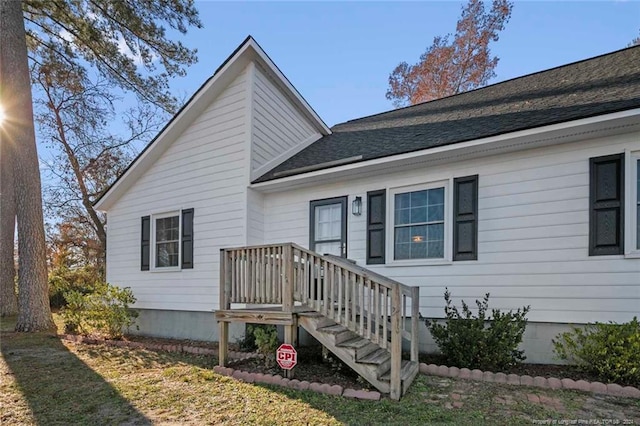 rear view of property featuring a lawn