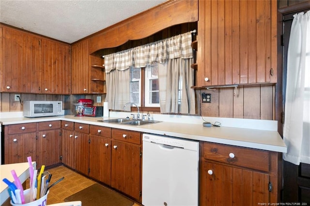 kitchen featuring a textured ceiling, crown molding, white appliances, and sink