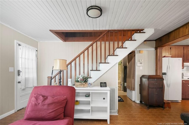 entrance foyer featuring wooden walls and ornamental molding