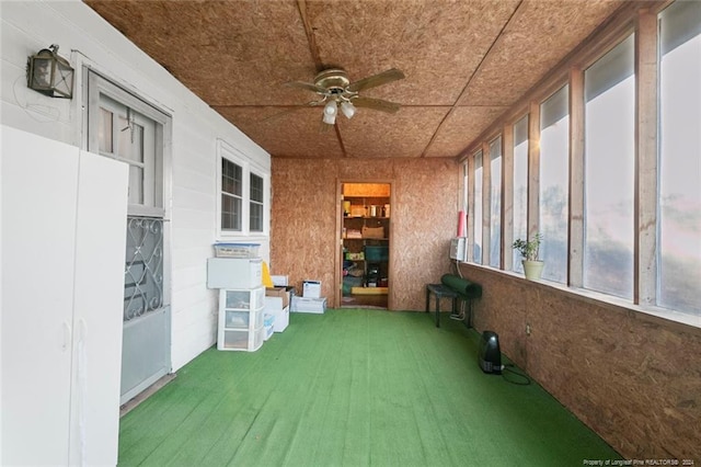 unfurnished sunroom featuring ceiling fan