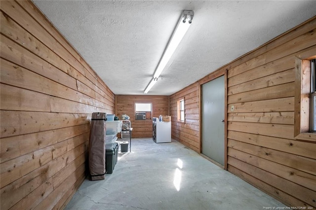 interior space featuring a textured ceiling and wooden walls