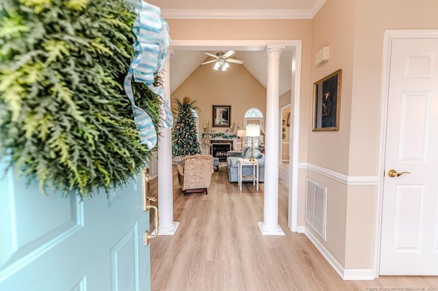 corridor featuring decorative columns, crown molding, light hardwood / wood-style floors, and vaulted ceiling