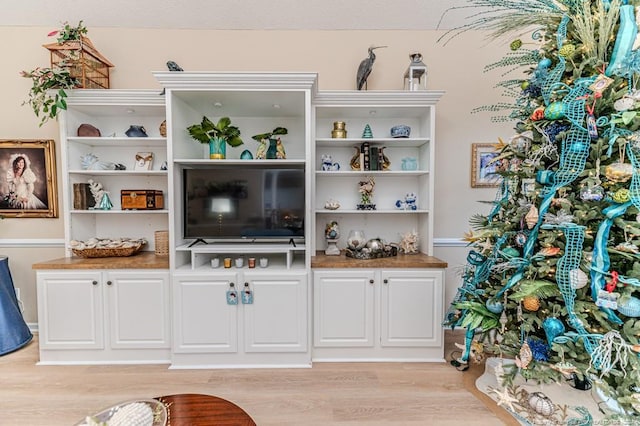 bar with white cabinets and light hardwood / wood-style floors