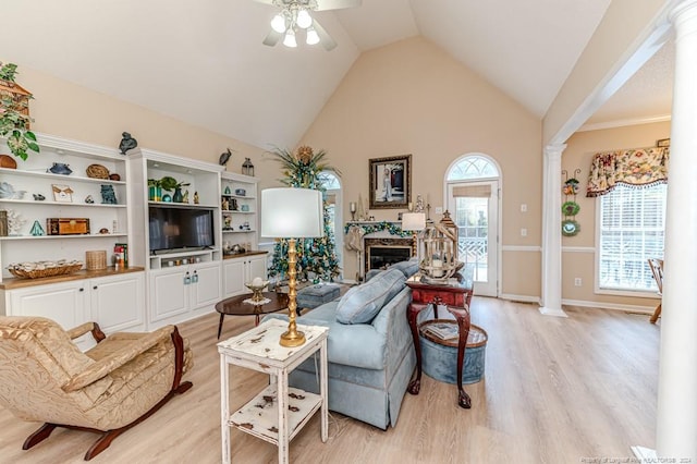 living room with high vaulted ceiling, decorative columns, light hardwood / wood-style flooring, and ceiling fan