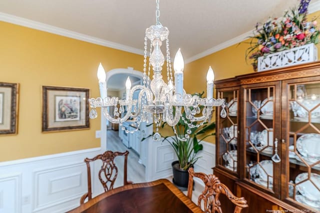 dining area with crown molding and a chandelier