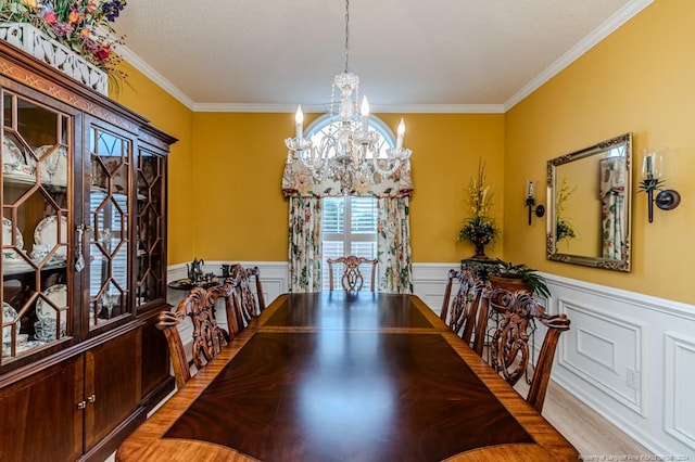 dining area featuring light wood-type flooring, crown molding, and an inviting chandelier