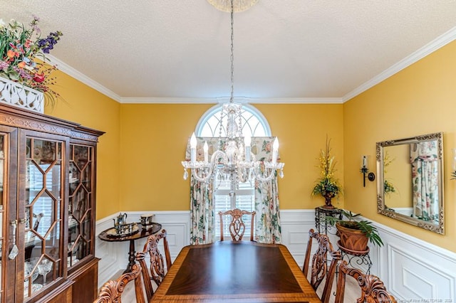 dining room featuring a textured ceiling, a notable chandelier, and crown molding