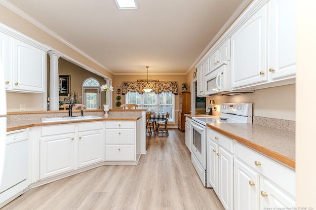 kitchen featuring white appliances, white cabinets, sink, light wood-type flooring, and decorative light fixtures