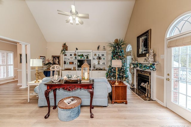 living room with high vaulted ceiling, a wealth of natural light, and light hardwood / wood-style flooring