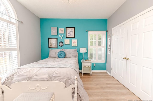 bedroom with light hardwood / wood-style flooring and a closet