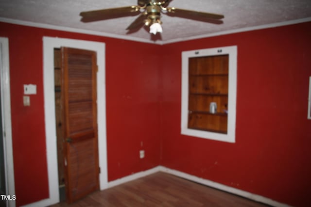 unfurnished bedroom with ceiling fan, wood-type flooring, and ornamental molding