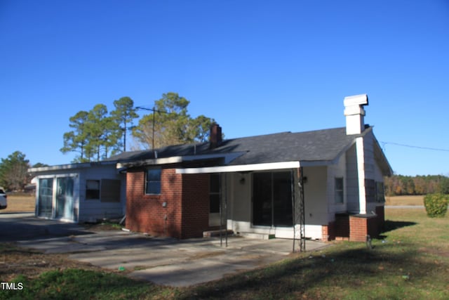 back of house featuring a garage and a lawn