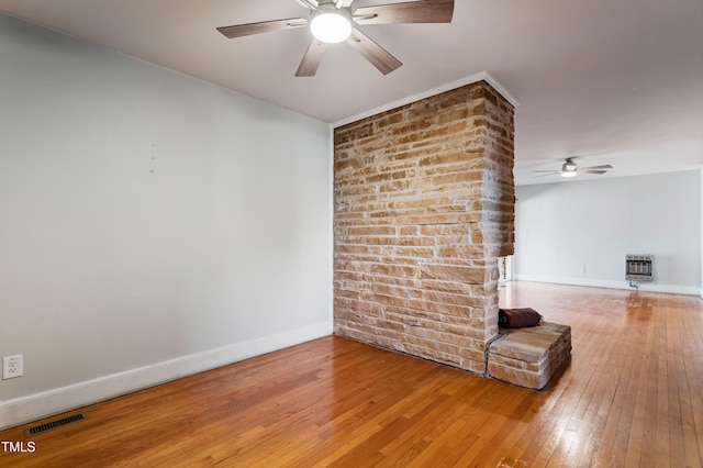 unfurnished living room featuring hardwood / wood-style floors, ceiling fan, and heating unit