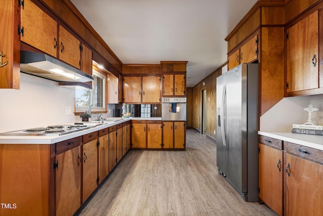 kitchen featuring light wood-type flooring, crown molding, and appliances with stainless steel finishes