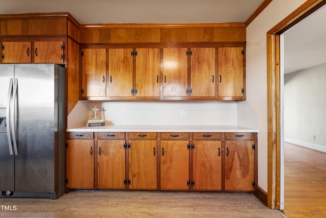 kitchen with stainless steel fridge with ice dispenser and light wood-type flooring