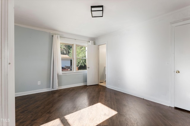 spare room featuring dark hardwood / wood-style flooring and ornamental molding