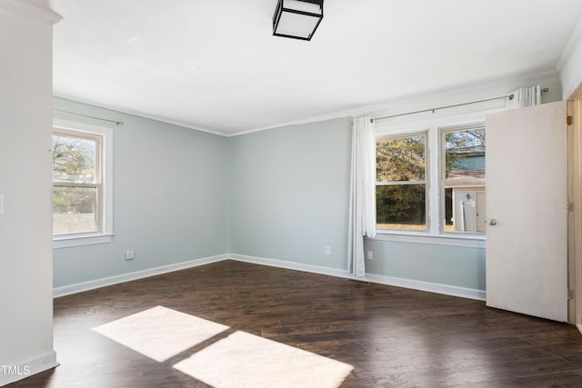 empty room with plenty of natural light, dark hardwood / wood-style floors, and ornamental molding