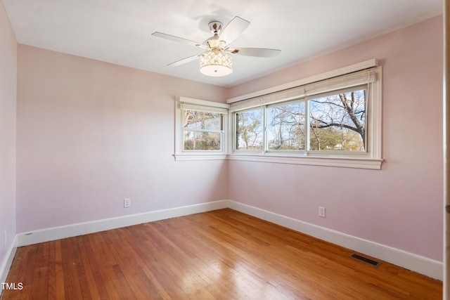 empty room with hardwood / wood-style floors and ceiling fan