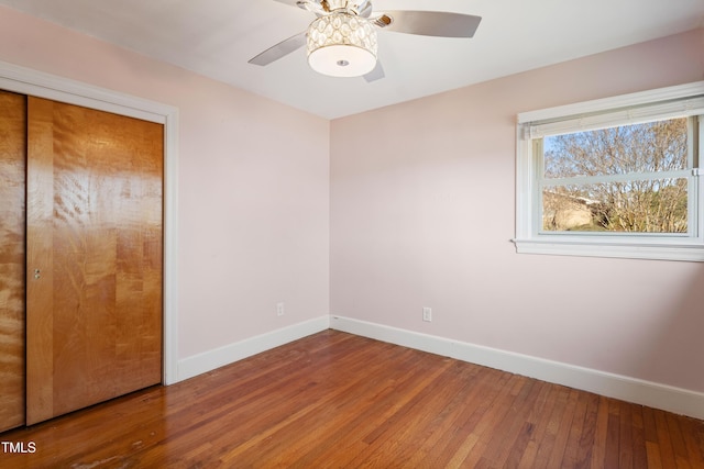 unfurnished bedroom with wood-type flooring, a closet, and ceiling fan