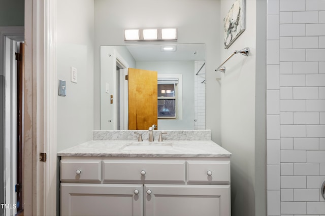 bathroom with vanity and a tile shower