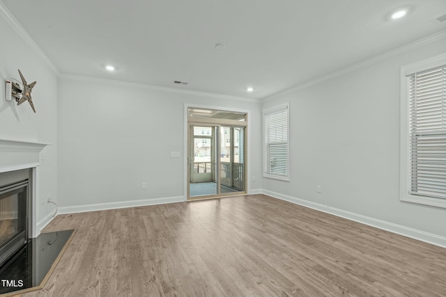 unfurnished living room featuring ornamental molding and light hardwood / wood-style flooring