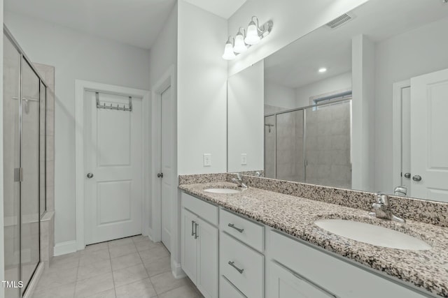 bathroom featuring tile patterned flooring, vanity, and a shower with shower door