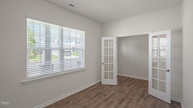 unfurnished room with french doors and dark wood-type flooring