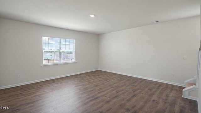 empty room with dark hardwood / wood-style flooring