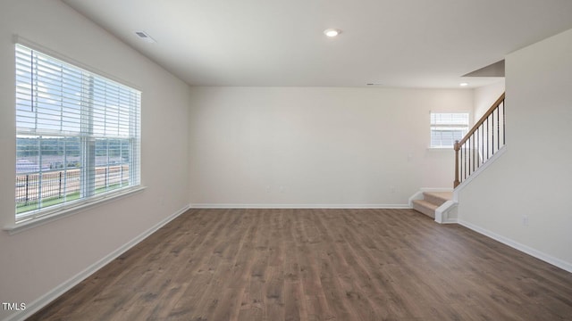 unfurnished room featuring dark hardwood / wood-style floors and a healthy amount of sunlight