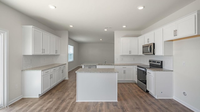 273 Hanging Elm Ln, Fuquay Varina, NC 27526 - kitchen with stainless steel appliances, backsplash, wood finished floors, white cabinetry, and recessed lighting