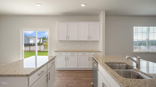 kitchen featuring white cabinets, hardwood / wood-style floors, light stone countertops, and sink