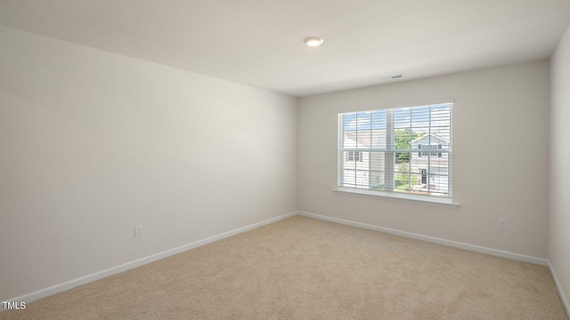 unfurnished room featuring light carpet