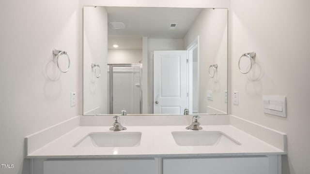 bathroom with a shower with door and vanity