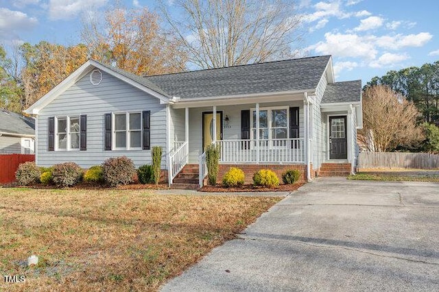 single story home featuring covered porch and a front lawn