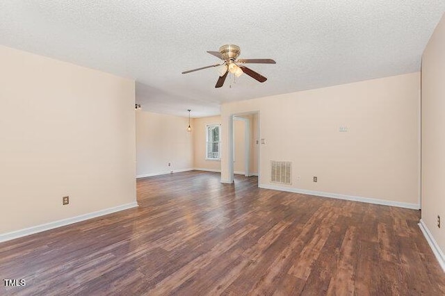 empty room featuring a textured ceiling, ceiling fan, and dark wood-type flooring