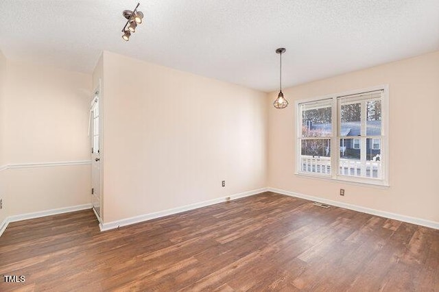 spare room with dark wood-type flooring and a textured ceiling