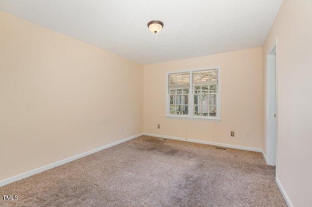 carpeted empty room with a textured ceiling