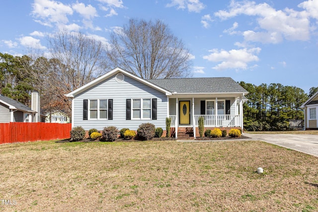 ranch-style house featuring a shingled roof, a front yard, covered porch, and fence