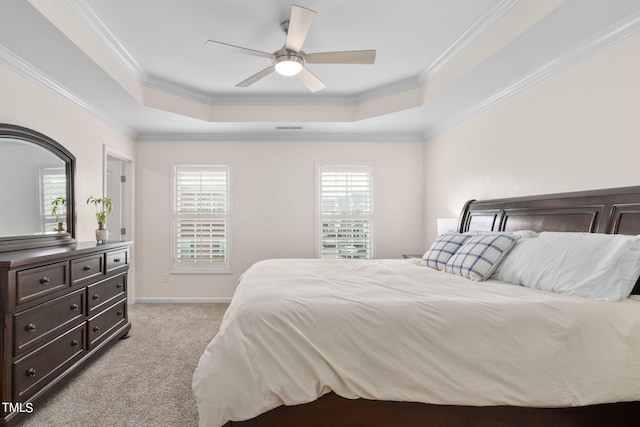 bedroom with a tray ceiling, ceiling fan, light carpet, and ornamental molding