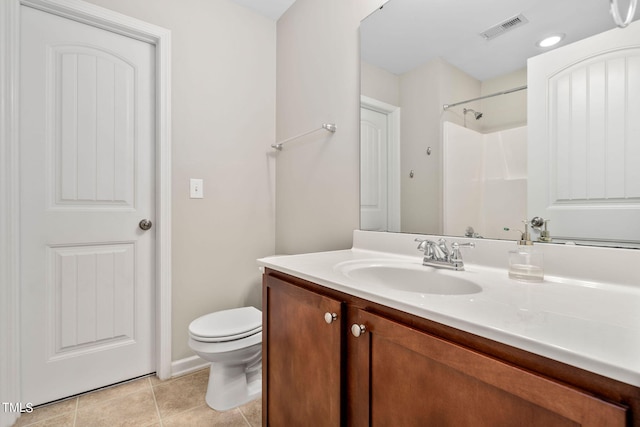 bathroom featuring tile patterned flooring, toilet, vanity, and walk in shower