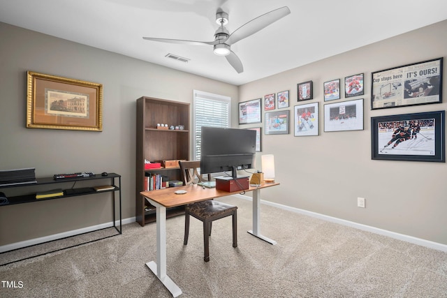 carpeted home office featuring ceiling fan