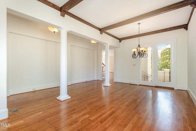 empty room with beamed ceiling, decorative columns, wood-type flooring, and a chandelier