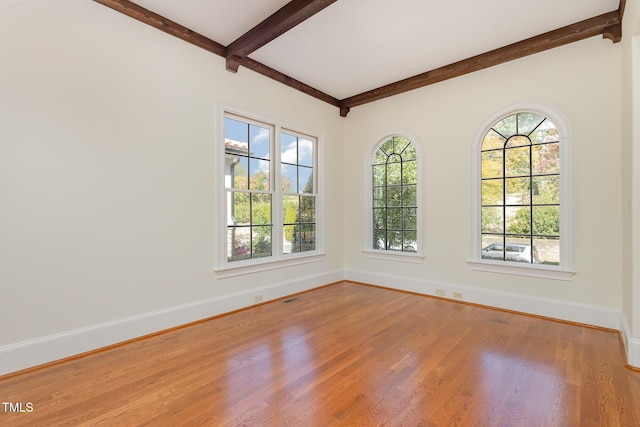 unfurnished room featuring beam ceiling and wood-type flooring