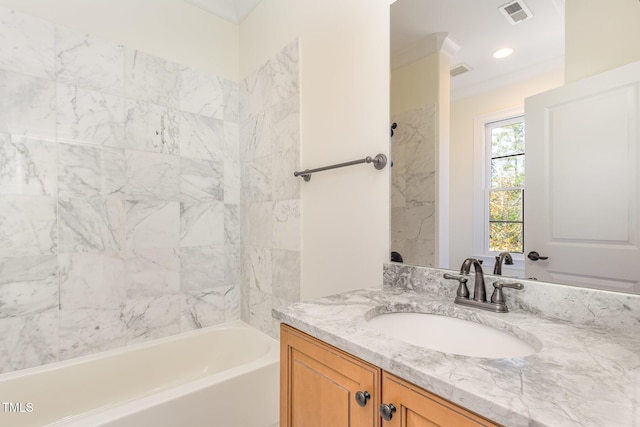 bathroom featuring tiled shower / bath, vanity, and ornamental molding