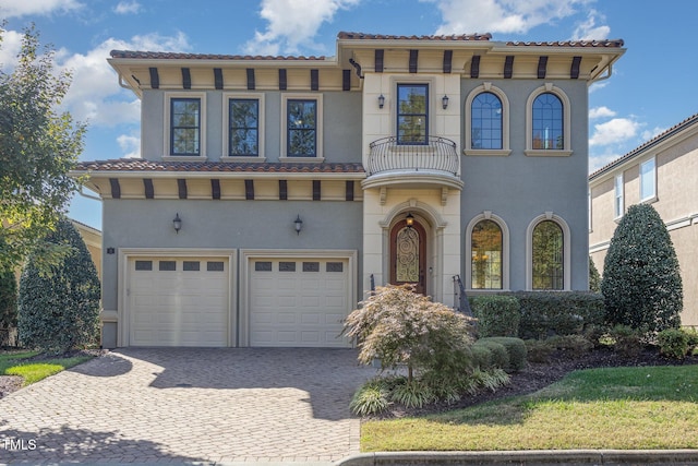 mediterranean / spanish-style home with a garage and a balcony