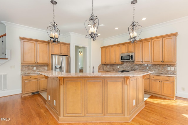 kitchen with decorative backsplash, appliances with stainless steel finishes, light wood-type flooring, and a center island with sink