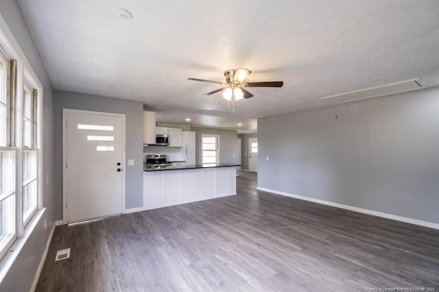 kitchen featuring white cabinets, ceiling fan, dark wood-type flooring, and stainless steel appliances