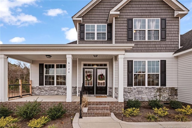 view of exterior entry featuring covered porch