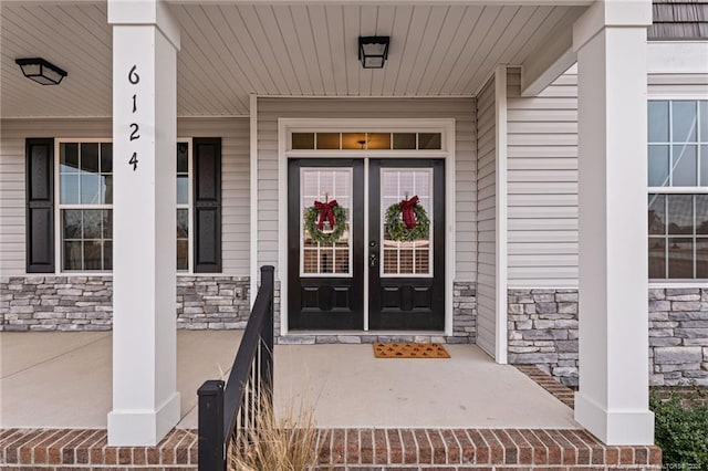 doorway to property featuring covered porch and french doors